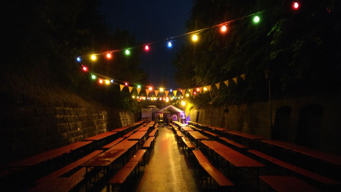 Die festlich beleuchtete Gasse Bromberg am Abend mit langen Biertischreihen